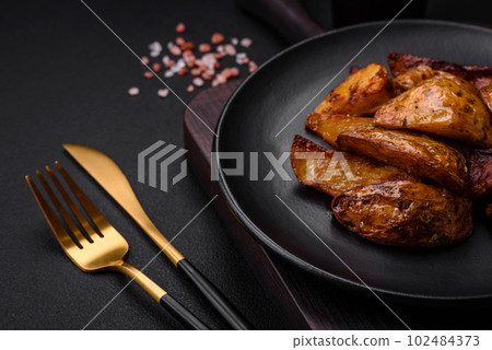 Delicious grilled potato slices with garlic, spices and herbs Delicious grilled potato slices with garlic, spices and herbs 102484373
