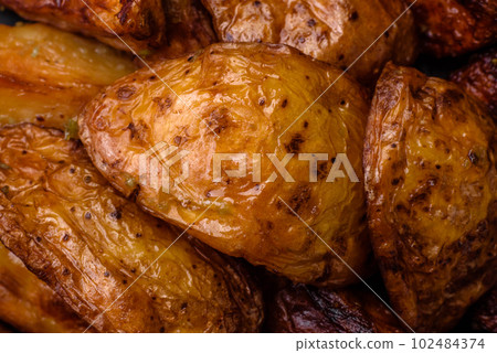 Delicious grilled potato slices with garlic, spices and herbs Delicious grilled potato slices with garlic, spices and herbs 102484374