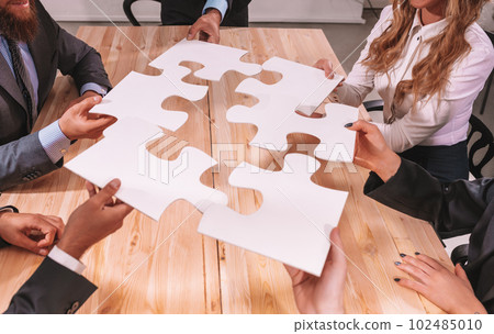 Teamwork of partners connect puzzle pieces as integration and startup 102485010