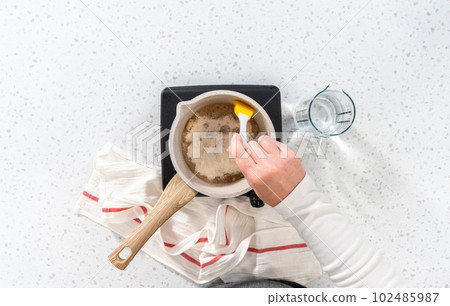 Flat lay. Caramelizing sugar in a saucepan to make caramel cupcake toppers. Flat lay. Caramelizing sugar in a saucepan to make caramel cupcake toppers. 102485987