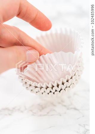 New white paper cupcake liners on the kitchen counter. 102485996