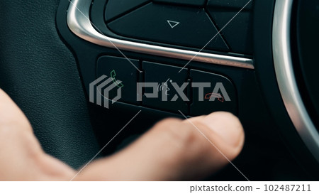 Finger presses end call car speaker button on the steering wheel 102487211