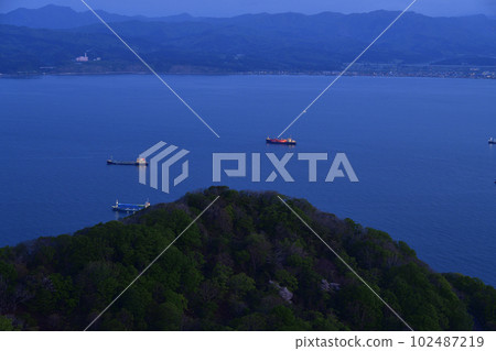 春天從函館山拍攝停泊在北海道函館市函館灣的貨船日出前的景色 春天從函館山拍攝停泊在北海道函館市函館灣的貨船日出前的景色 102487219