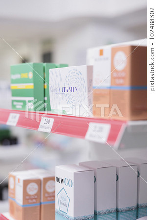 Selective focus of pharmacy shelves full with spf products and pharmaceuticals drugs boxes to sell prescription medicine or treatment to clients. Empty health care store filled with vitamins and pills Selective focus of pharmacy shelves full with spf products and pharmaceuticals drugs boxes to sell prescription medicine or treatment to clients. Empty health care store filled with vitamins and pills 102488302