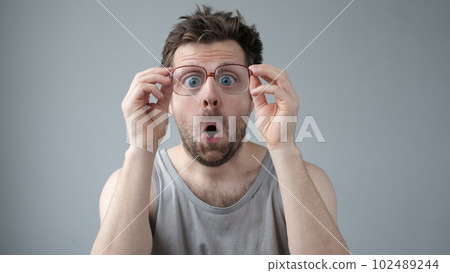Surprised man in big glasses with WOW expression on gray backgound Surprised man in big glasses with WOW expression on gray backgound 102489244