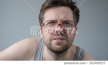 Surprised man in big glasses with WOW expression on gray backgound Surprised man in big glasses with WOW expression on gray backgound 102489257