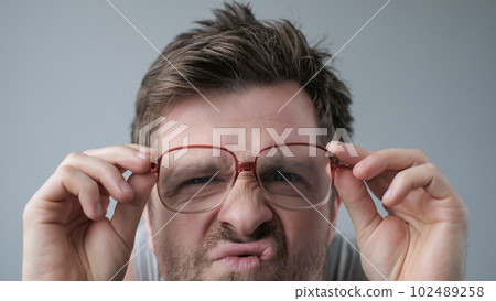 Surprised man in big glasses with WOW expression on gray backgound Surprised man in big glasses with WOW expression on gray backgound 102489258