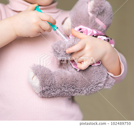 Little teddy bear vaccinated by little girl. 102489750