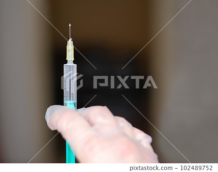 Doctor hand in white glove holdes syringe with vaccine. Doctor hand in white glove holdes syringe with vaccine. 102489752