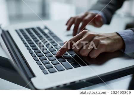 Close-up of male hands using laptop at office 102490869