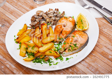 Grilled salmon steak with potato and mushrooms 102491775