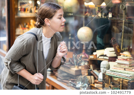 Young woman looking at vintage items at flea market Young woman looking at vintage items at flea market 102491779