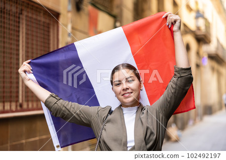 Happy female tourist walking old streets with flag of france 102492197