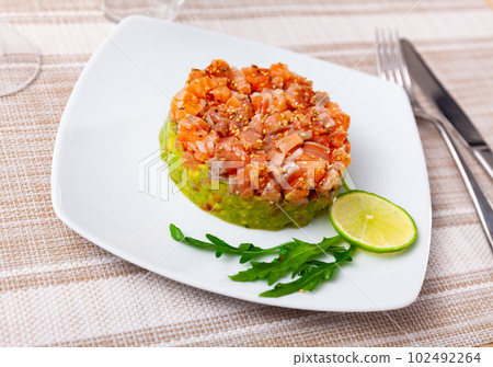 Salmon tartare with guacamole and slice of lime 102492264
