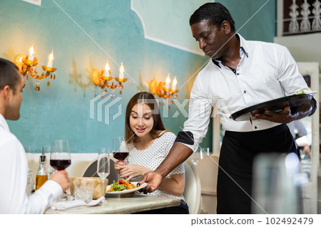 Waiter serving restaurant guests 102492479