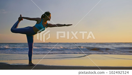 woman practice yoga on beach woman practice yoga on beach 102492524