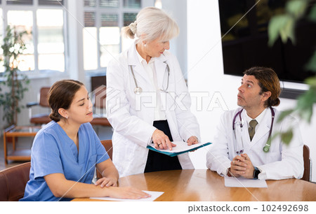 Senior female head doctor conducting medical council with colleagues Senior female head doctor conducting medical council with colleagues 102492698