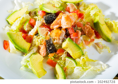 Closeup of salad with fried salmon, avocado, tomatoes and lettuce 102492728