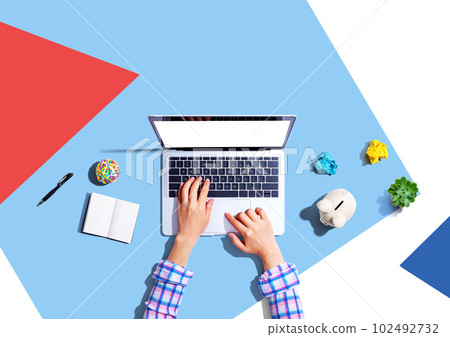 Laptop computer with a piggy bank and office objects 102492732