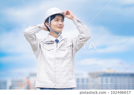 An engineer wearing a helmet checking the site outdoors An engineer wearing a helmet checking the site outdoors 102496657