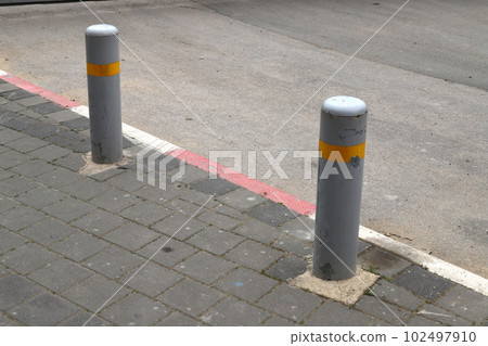 fencing along the road for the safety of pedestrians on the sidewalk 102497910