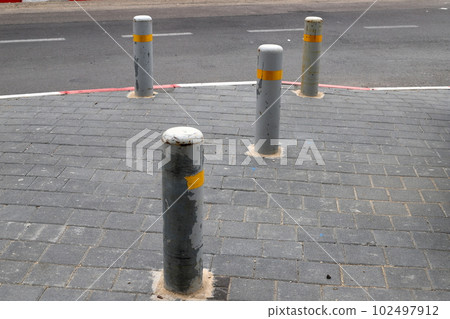 fencing along the road for the safety of pedestrians on the sidewalk 102497912