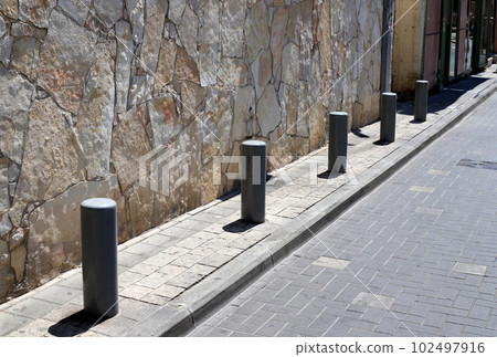 fencing along the road for the safety of pedestrians on the sidewalk fencing along the road for the safety of pedestrians on the sidewalk 102497916