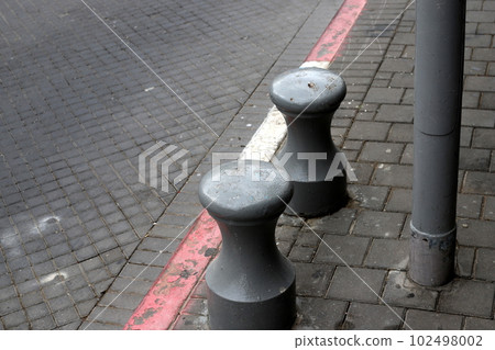fencing along the road for the safety of pedestrians on the sidewalk fencing along the road for the safety of pedestrians on the sidewalk 102498002