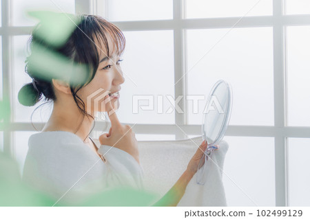 Asian women checking their teeth in the mirror (whitening, orthodontics, implants) Asian women checking their teeth in the mirror (whitening, orthodontics, implants) 102499129