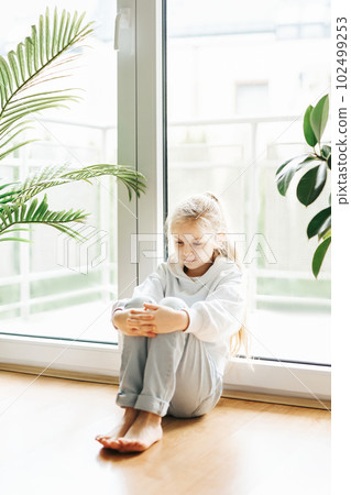 Lonely sad girl near the window. 102499253