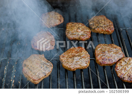 Grilled American beef burgers are cooked on over hot grill Grilled American beef burgers are cooked on over hot grill 102500399
