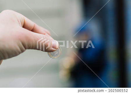 Street old performer musician plays saxofon blurred, coin in hand focused 102500552