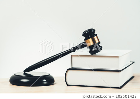 Black wooden gavel and book on office desk as justice and legal. equility 102501422