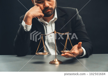 Lawyer or judge in formal black suit hold unbalanced scale . equility 102501684