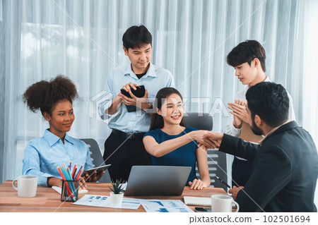 Diverse coworkers celebrate success with handshake. Concord 102501694