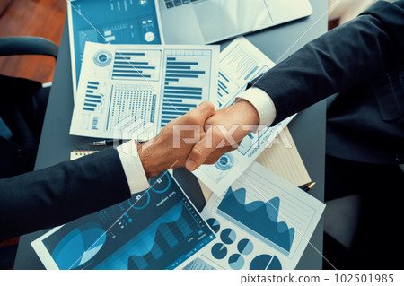 Top view businessman handshake over desk with BI papers. fervent Top view businessman handshake over desk with BI papers. fervent 102501985