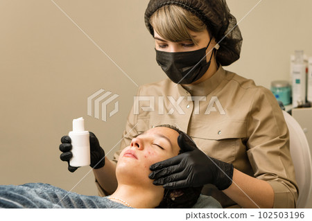 Beautician apply serum for face on teen skin Beautician apply serum for face on teen skin 102503196