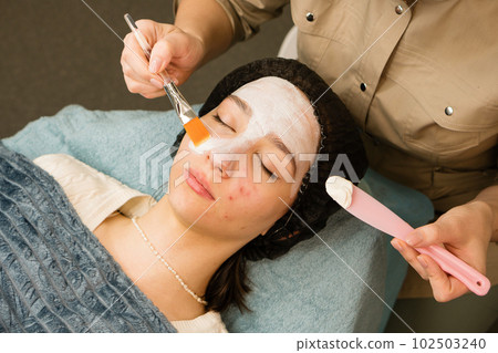 Acne treatment at doctor. Applying facial mask 102503240
