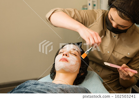 Acne treatment at doctor. Applying facial mask 102503241