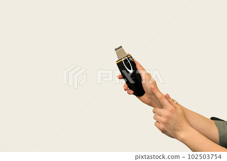 Beautician's hands with Ultrasonic scrubber 102503754