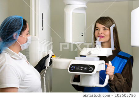 X-ray technician makes CT scan of jaw 102503786