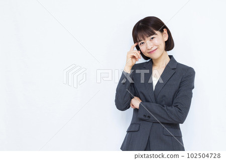 A woman in her thirties in a suit thinking with a smile in front of a white background A woman in her thirties in a suit thinking with a smile in front of a white background 102504728