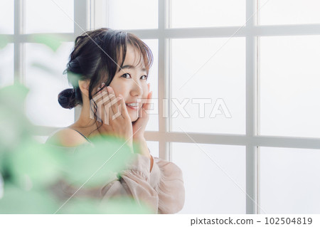 微笑的亞洲女性在家撫摸臉頰進行皮膚護理 102504819