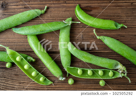 Fresh pea pods on a wooden background 102505292