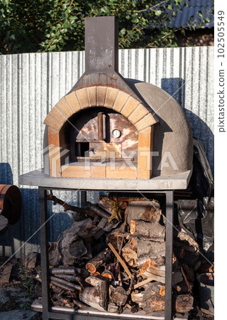 Cooking real pizza in a brick oven. Wood and fire are burning 102505549
