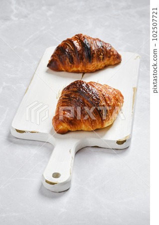 Fresh croissant for breakfast on serving board on marble background 102507721