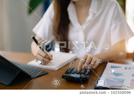 Businesswoman working with tablet and using a calculator to calculate the numbers of static in office. Finance accounting concept. Businesswoman working with tablet and using a calculator to calculate the numbers of static in office. Finance accounting concept. 102508096