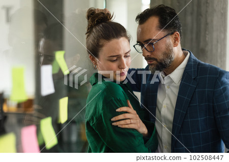 Mature man abusing his younger colleague, concept of harassment at workplace. 102508447