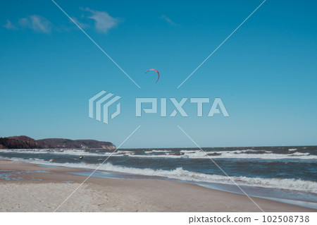 Wing Foiling kitesurfing wind surfing water outdoor sport in Baltic sea Dark blue clouds ocean water surface with foam waves before storm, dramatic seascape 102508738