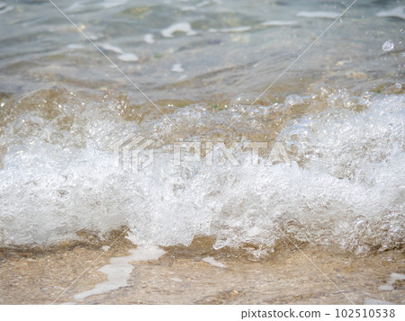 海浪拍打在沙灘上的特寫鏡頭。 海浪拍打在沙灘上的特寫鏡頭。 102510538